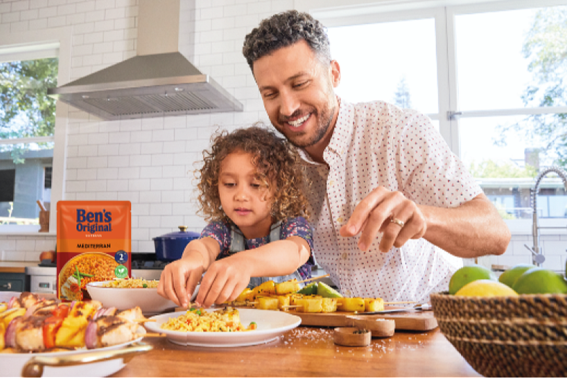 Father and daughter cooking in kitchen